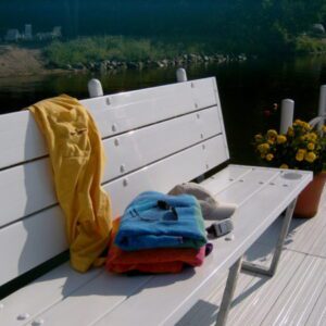 Towels and flowers on lakeside bench
